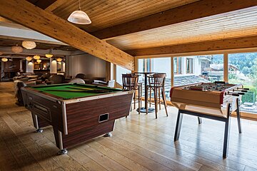 A game room with a pool table and a foosball table