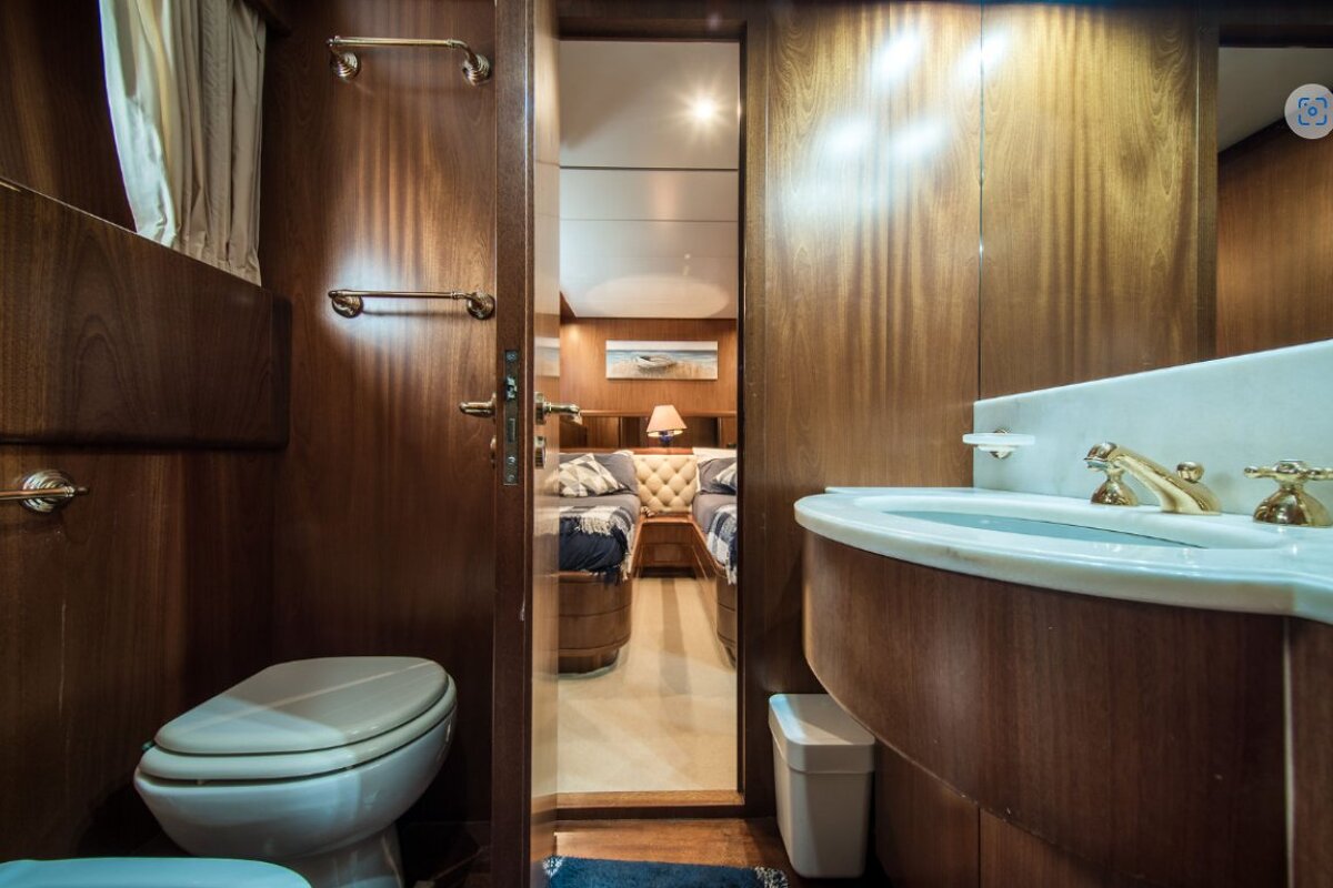 A bathroom with a toilet a sink and a trash can