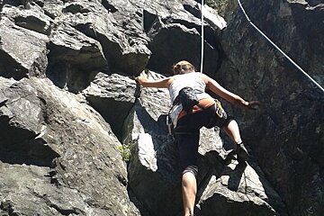 a climber heading up a rock face