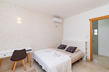 A bedroom with a single bed and a desk