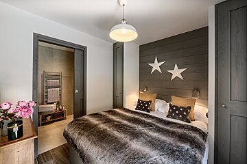 A bedroom with a bed and two stars on the wall