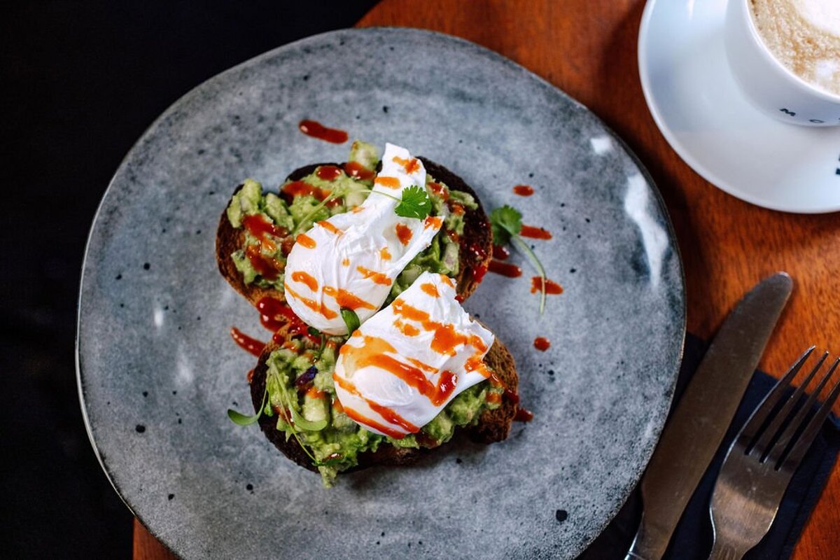 A plate of food with avocado and poached eggs on it