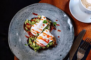A plate of food with avocado and poached eggs on it