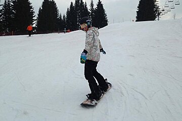 a snowboarder with their arms out front & back