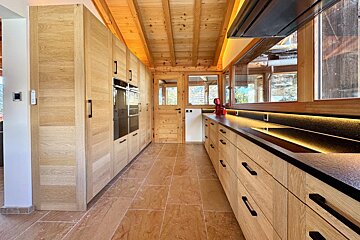 A kitchen with wooden cabinets and black counter tops