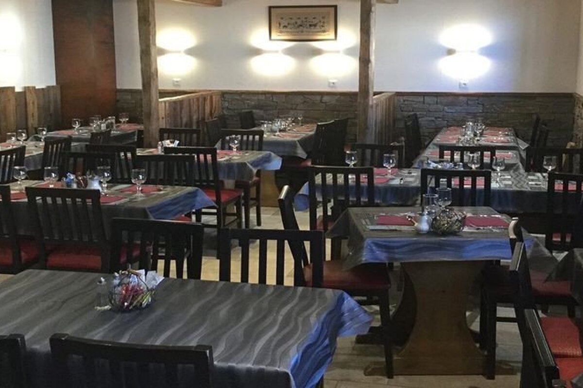 A restaurant with tables and chairs and a sign on the wall that says 