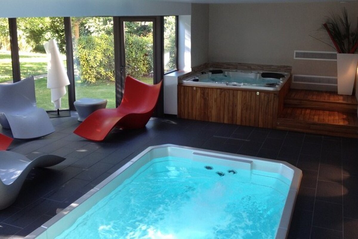 A room with a pool and a jacuzzi in it