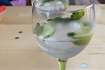 A wine glass filled with ice cubes and lime slices