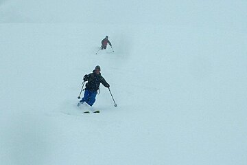 two skiers in snowy conditions