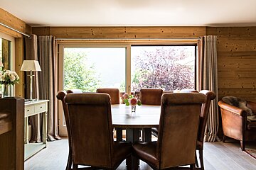 A dining room table with a vase of flowers on it