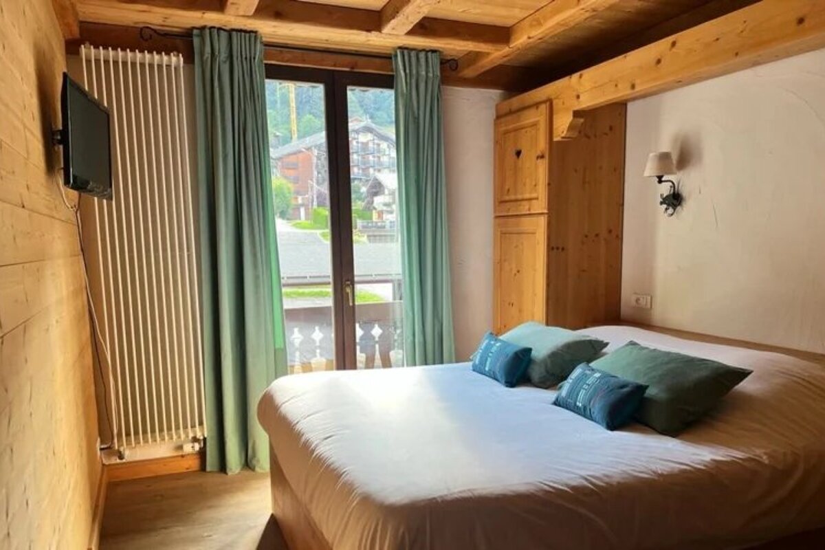 A bedroom with a large bed and a flat screen tv