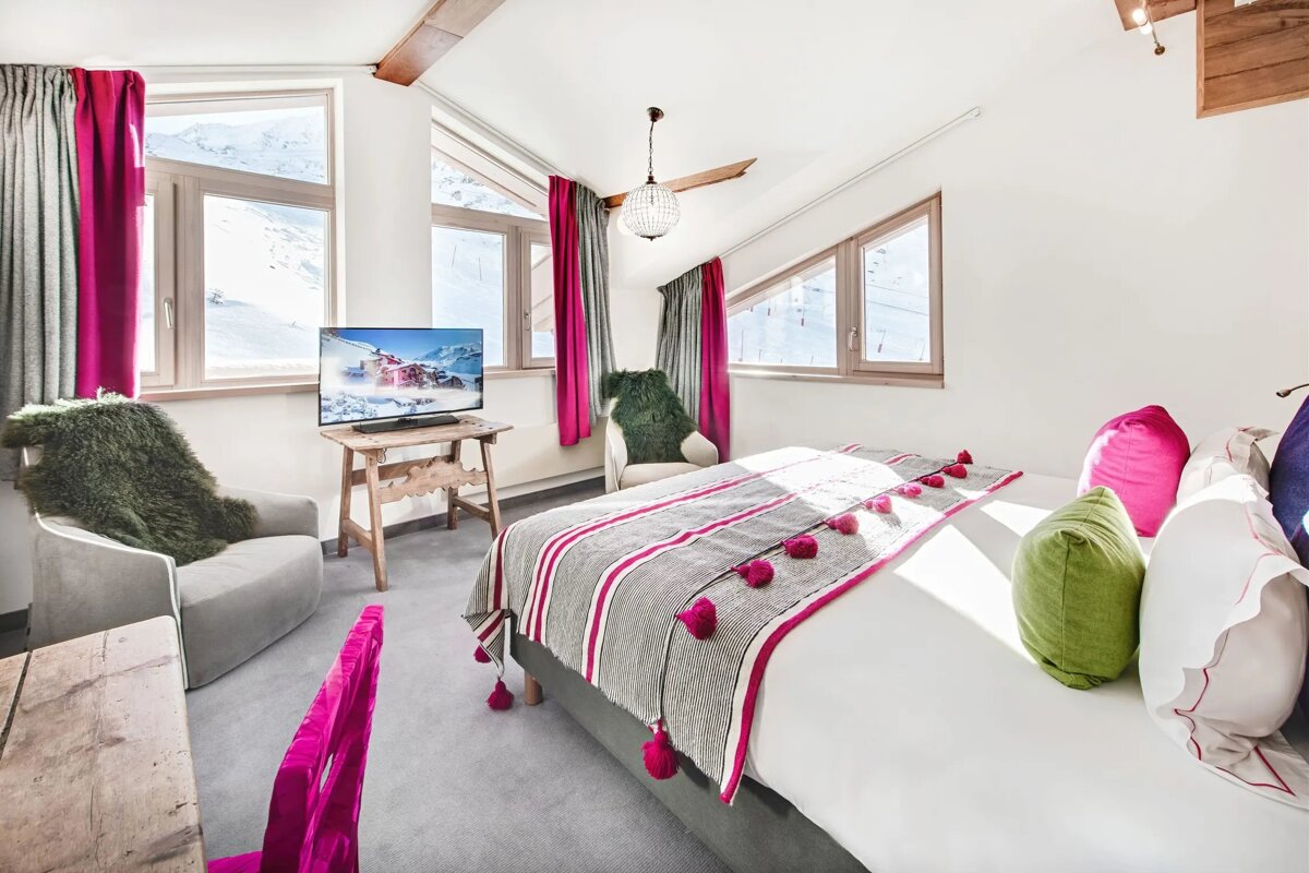 A bedroom with a large bed and a flat screen tv