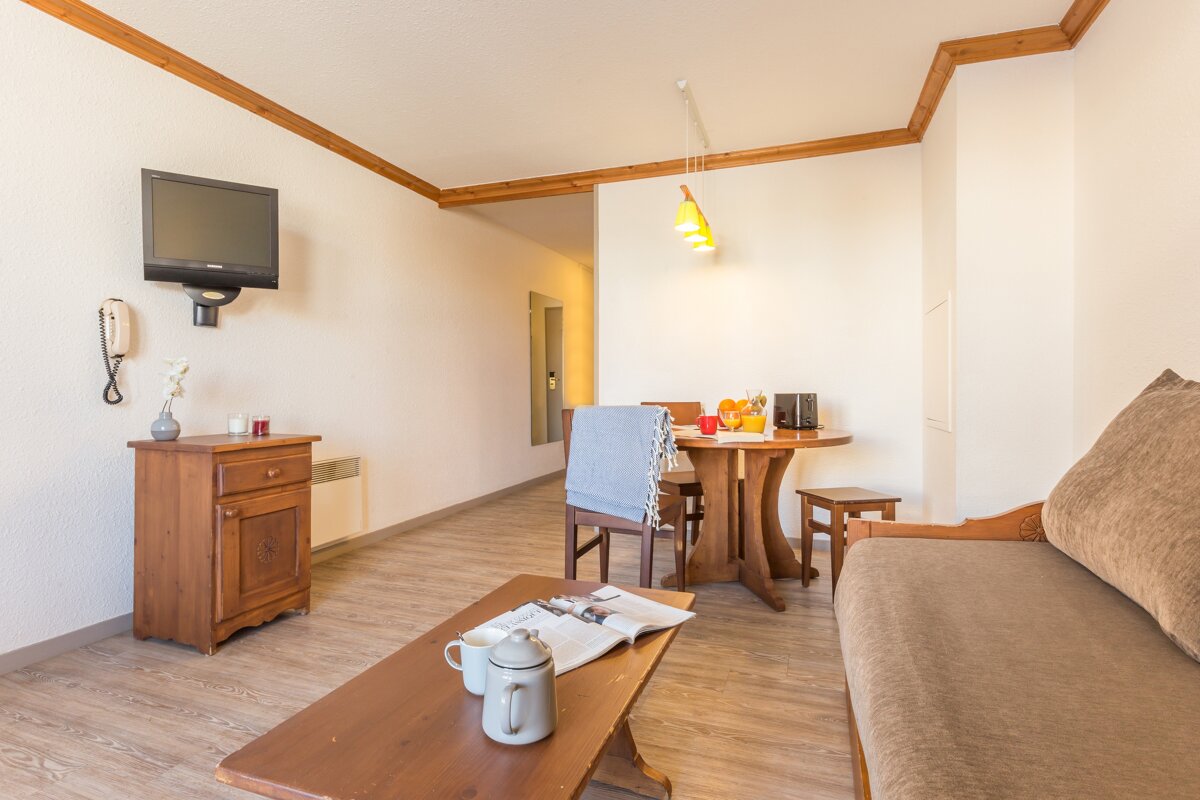 A living room with a couch a table and a television