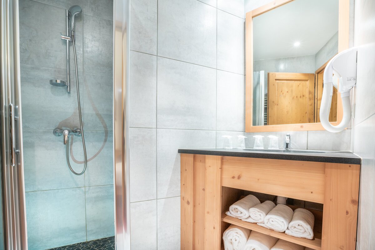 A bathroom with a wooden vanity and a shower