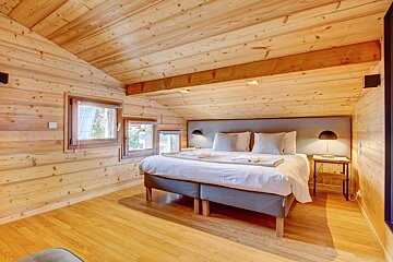 A bedroom in a log cabin with a king size bed