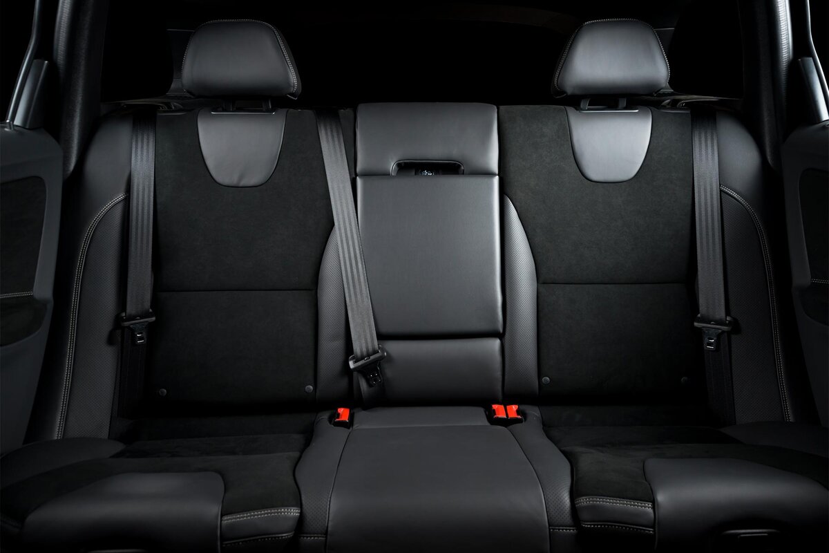 The back seat of a car with the seat belts on