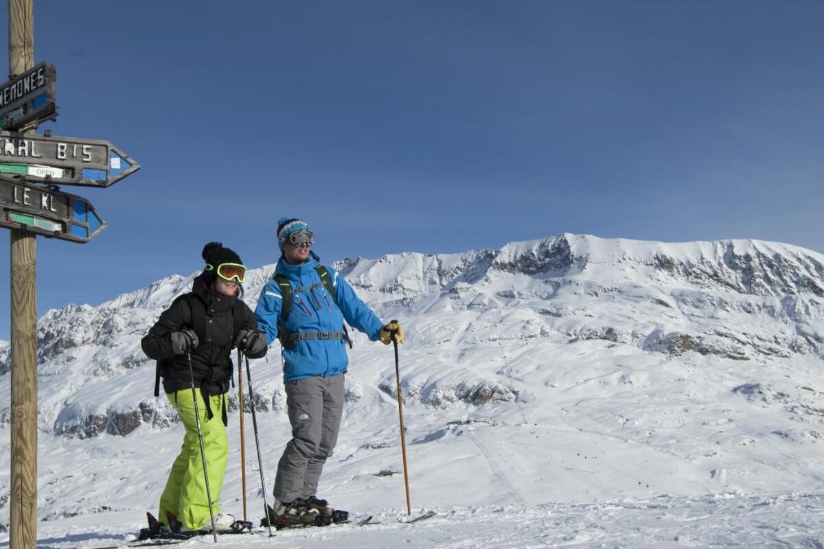 a piste marker and two skiers