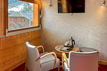 A small room with two chairs and a flat screen tv