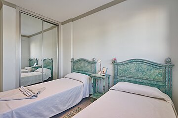 A bedroom with two beds and a mirrored closet