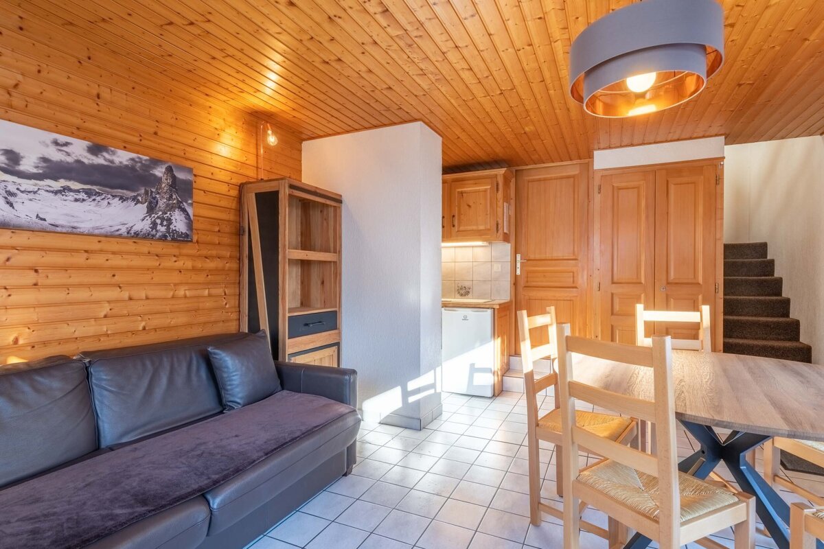 A living room with a couch a table and chairs