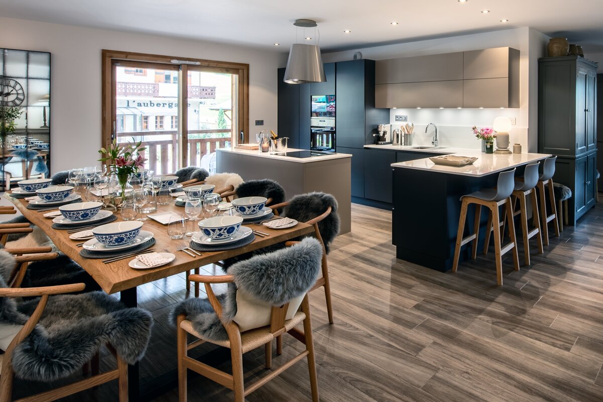 A kitchen and dining area with a clock on the wall that says l' auberge