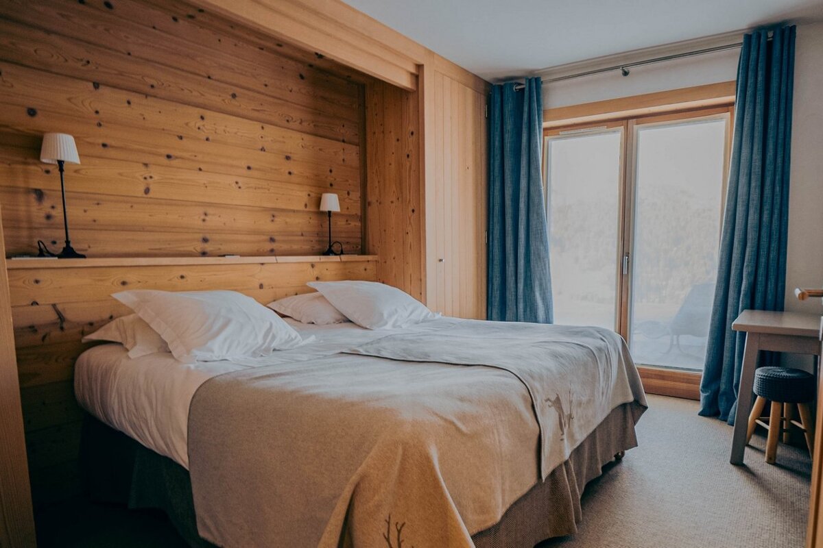 A bedroom with a large bed and blue curtains