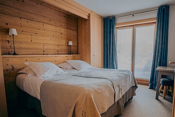 A bedroom with a large bed and blue curtains