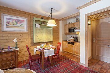 A room with a table and chairs and a picture on the wall