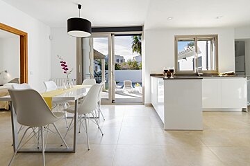 A kitchen with a table and chairs and a sliding glass door