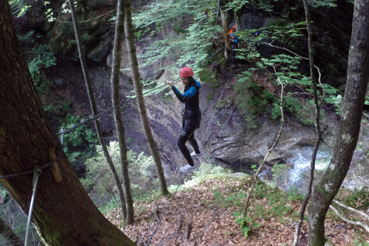 a person on a high wire across a river gully