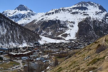 A small town in the mountains with a mountain in the background