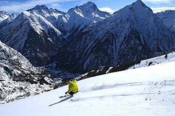a skier in a yellow jacket