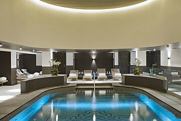 A large indoor swimming pool with chairs around it