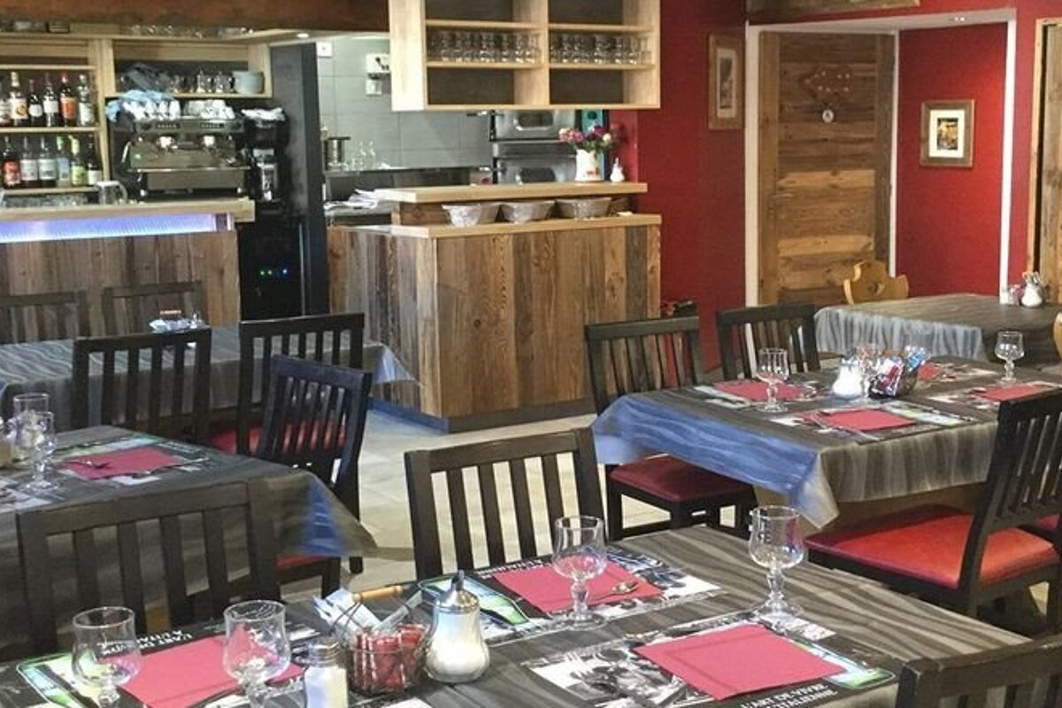 A restaurant with tables and chairs and a sign that says ' les glaciers ' on it