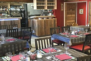 A restaurant with tables and chairs and a sign that says ' les glaciers ' on it