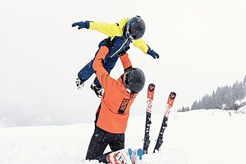 A person wearing an orange jacket with the word impact on it