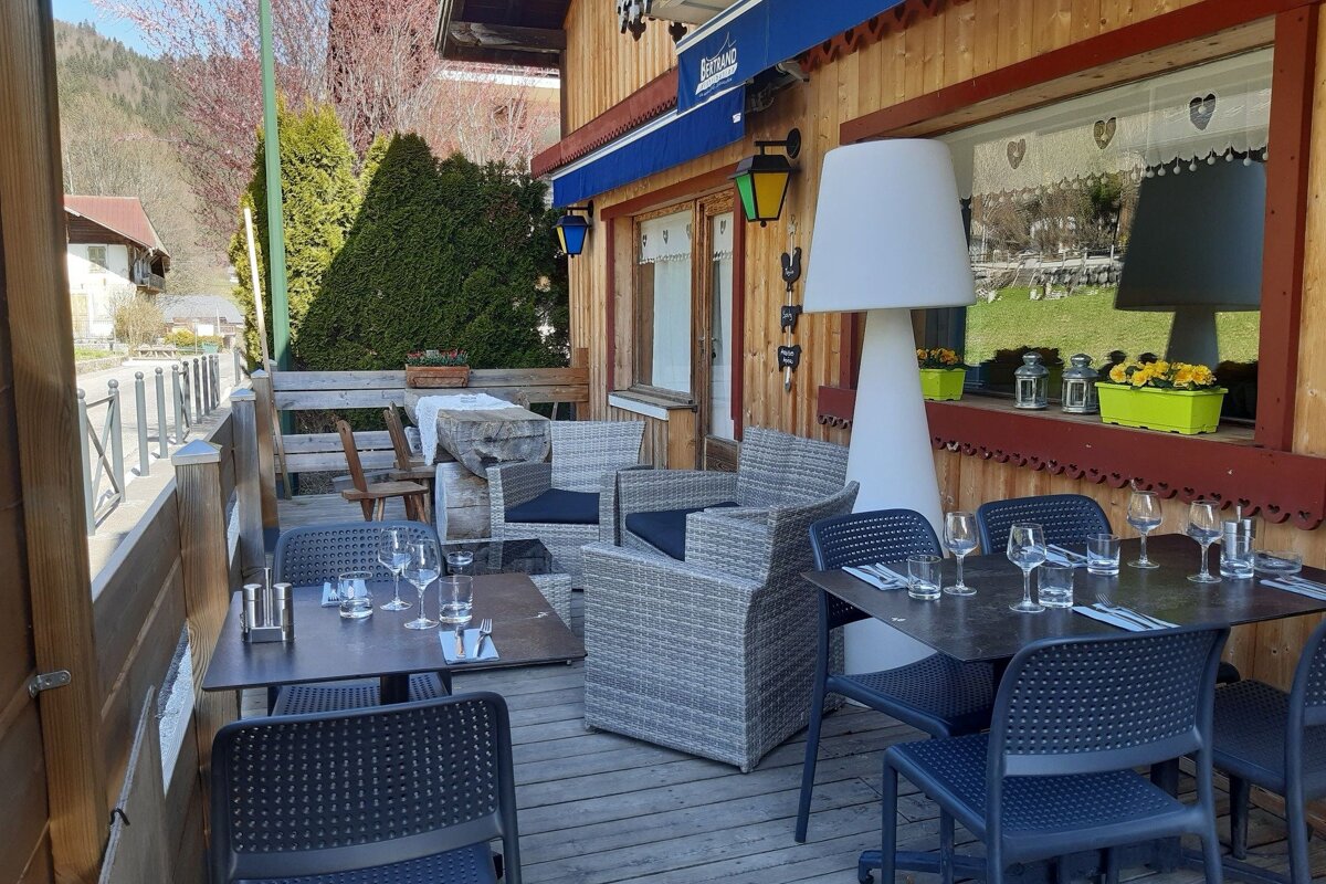 Tables and chairs outside of a restaurant with a blue awning that says bistro