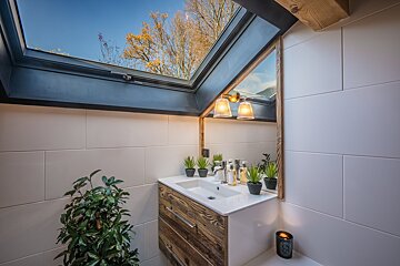 A bathroom with a skylight above the sink