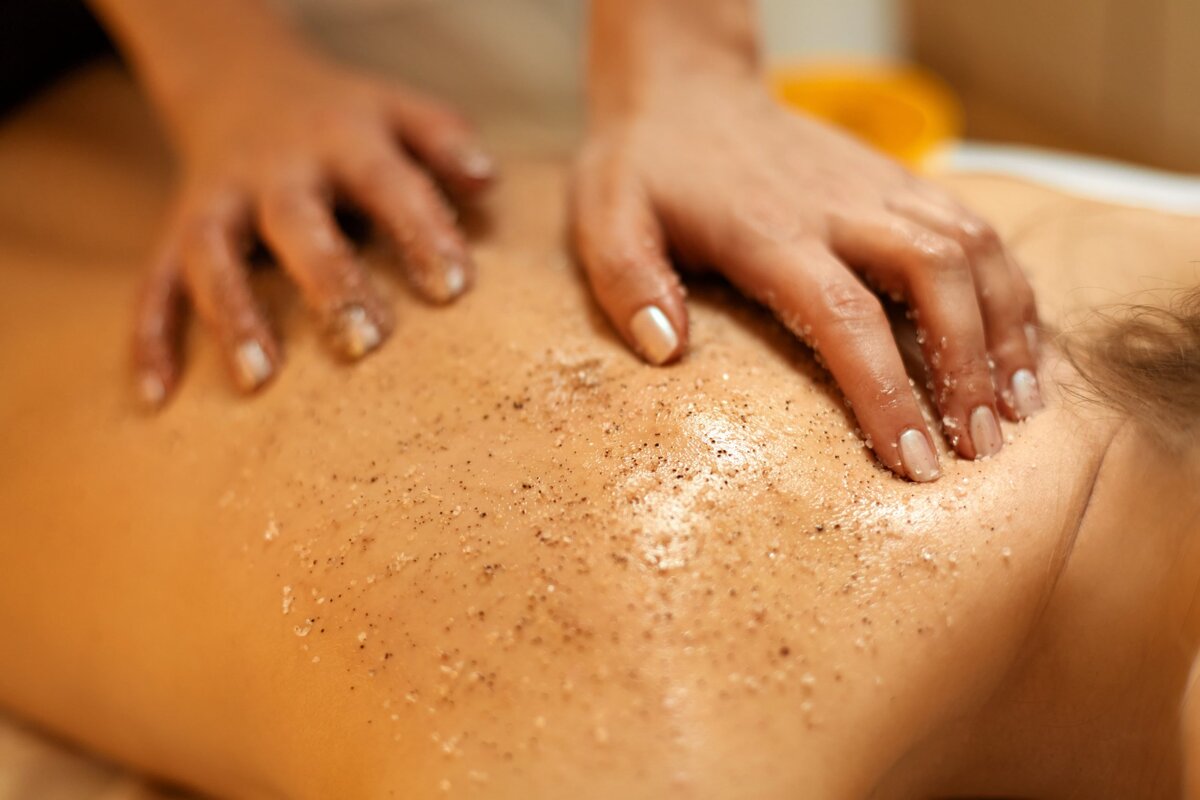A woman is getting a body scrub on her back