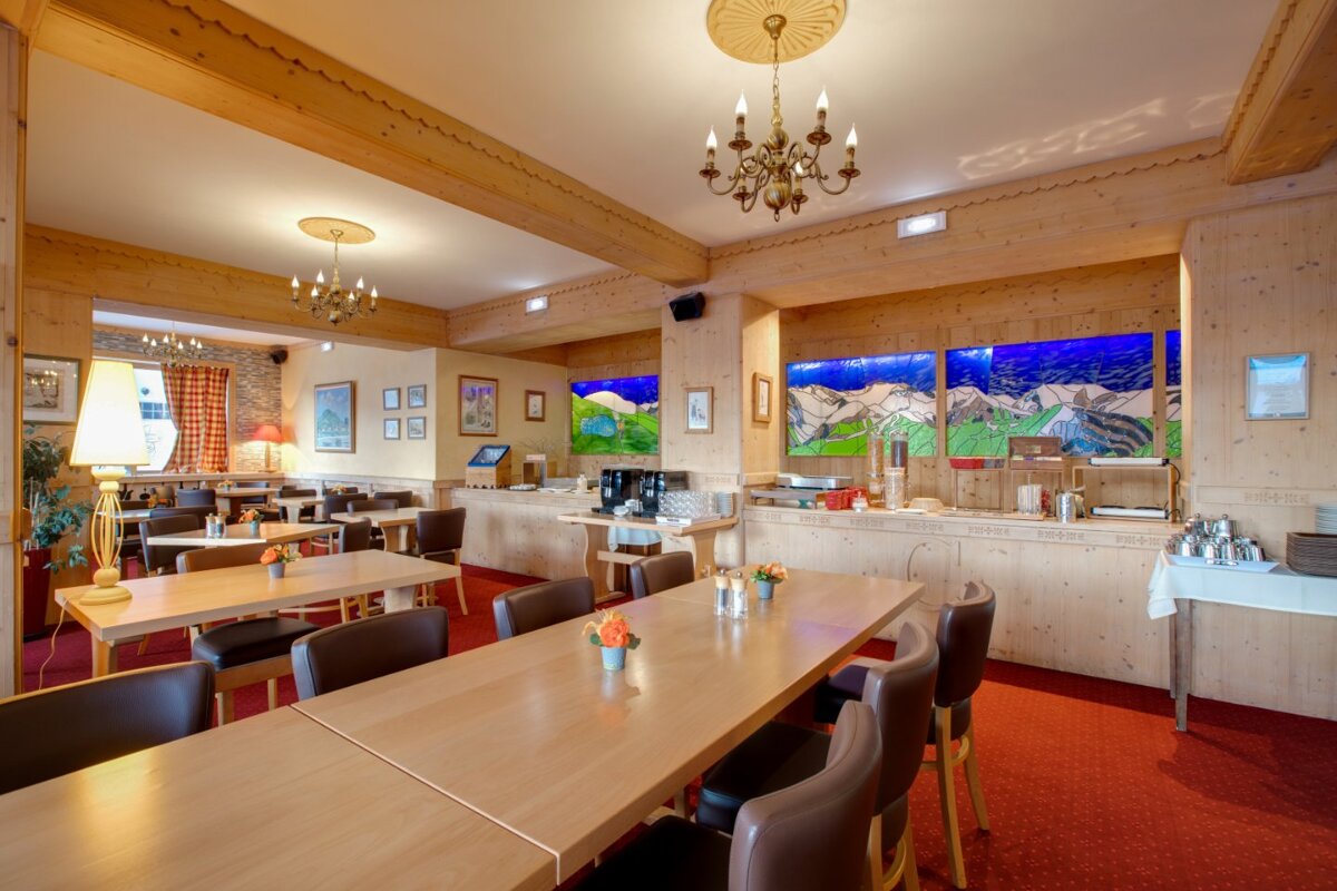 A dining room with tables and chairs and a chandelier