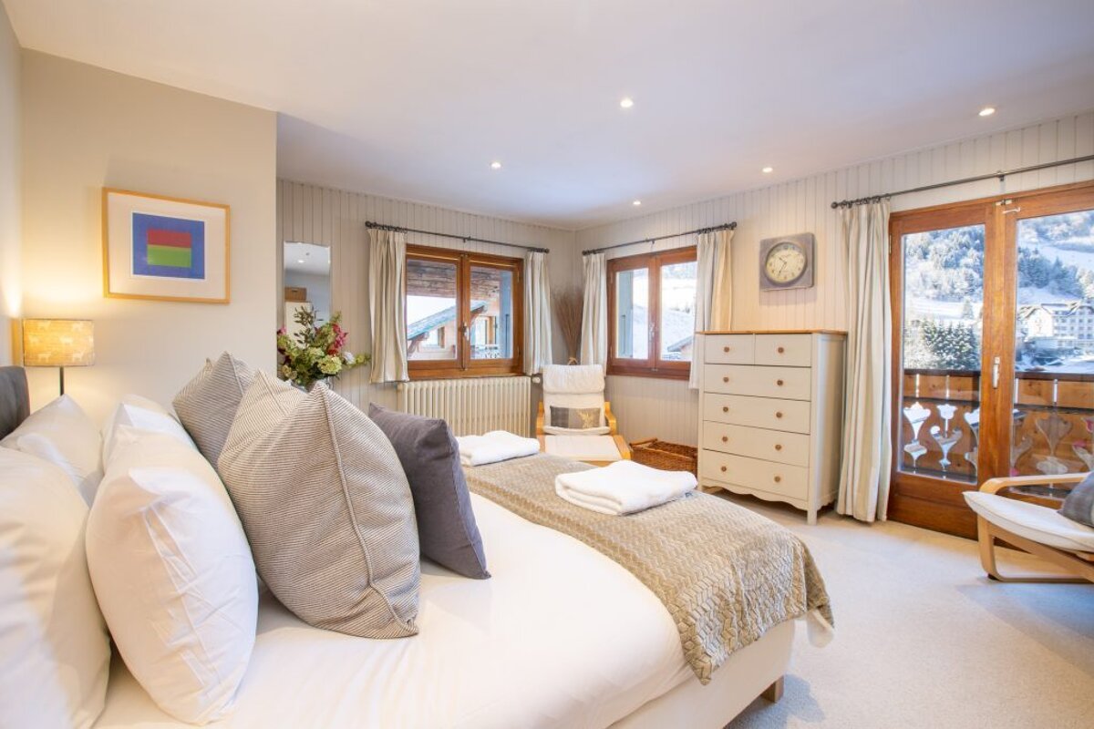 A bedroom with a large bed and a clock on the wall