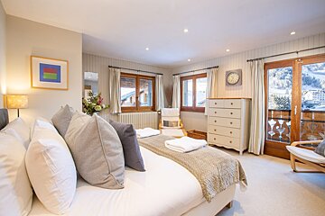A bedroom with a large bed and a clock on the wall