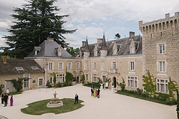 A group of people standing in front of a large stone building