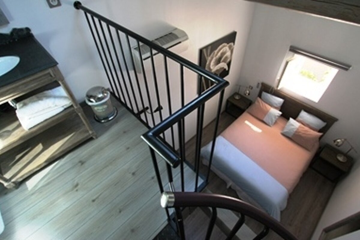 An aerial view of a bedroom with a spiral staircase