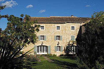 A large stone building with blue shutters on the windows