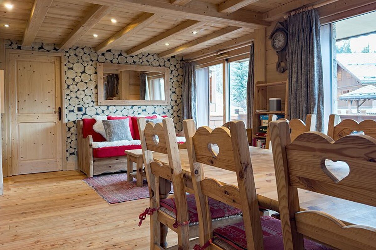 A dining room with a table and chairs and a clock on the wall