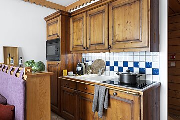 A kitchen with wooden cabinets and a black pot on the stove