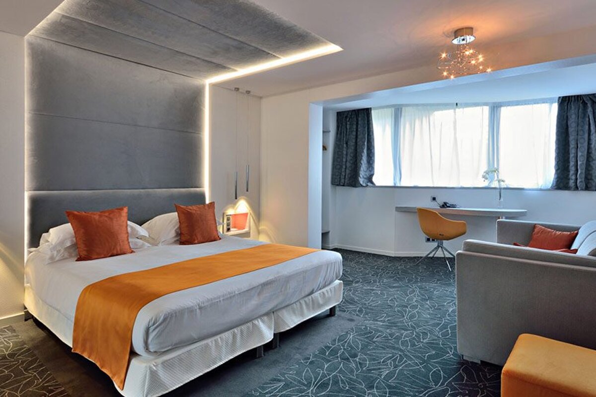 A hotel room with a large bed and a couch