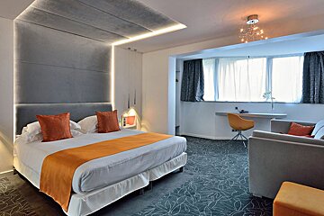 A hotel room with a large bed and a couch