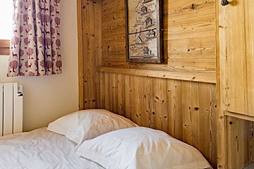 A bedroom with a bed and a picture on the wall
